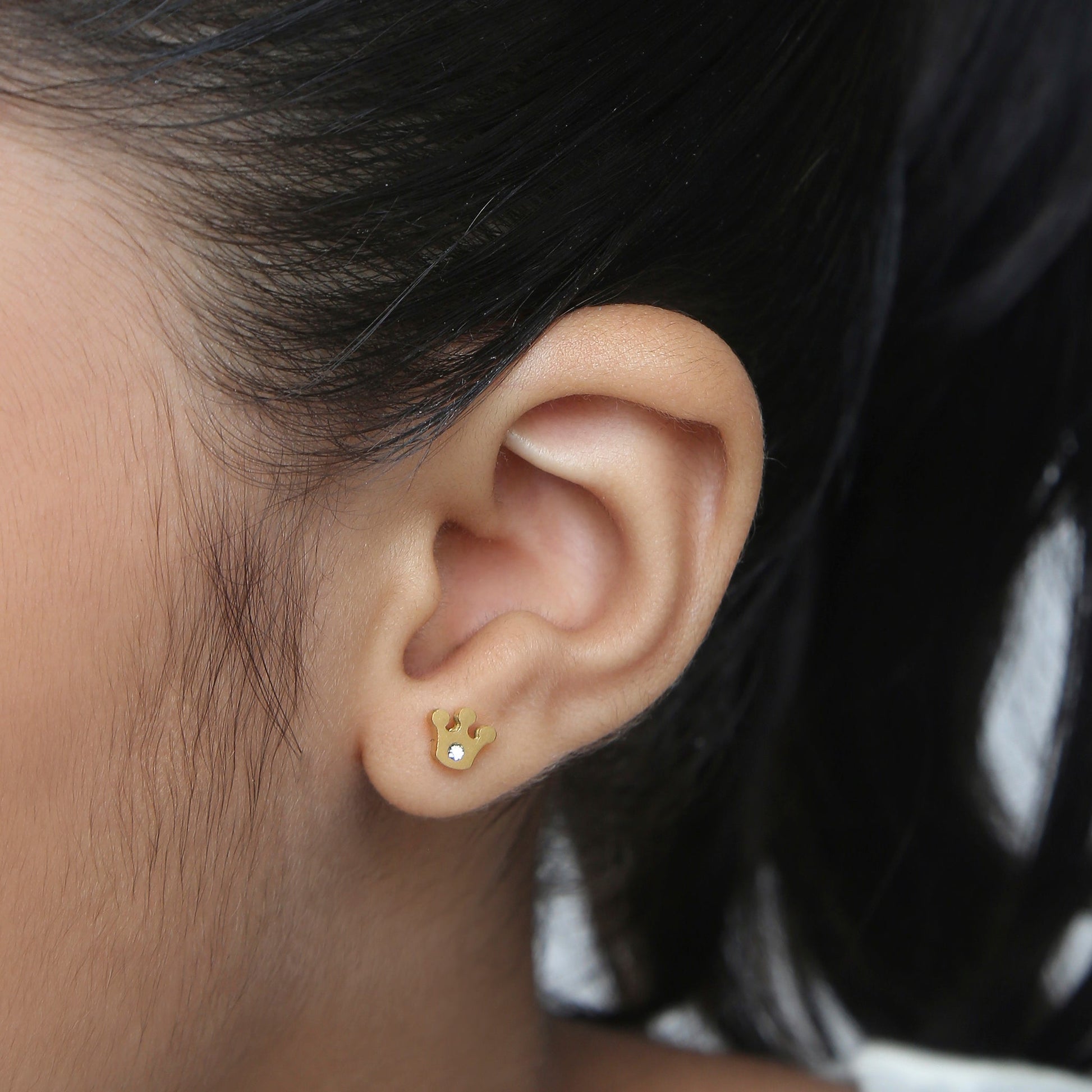 Girl wearing Sparkle Crown gold earrings – kids jewellery by Twisty Locks