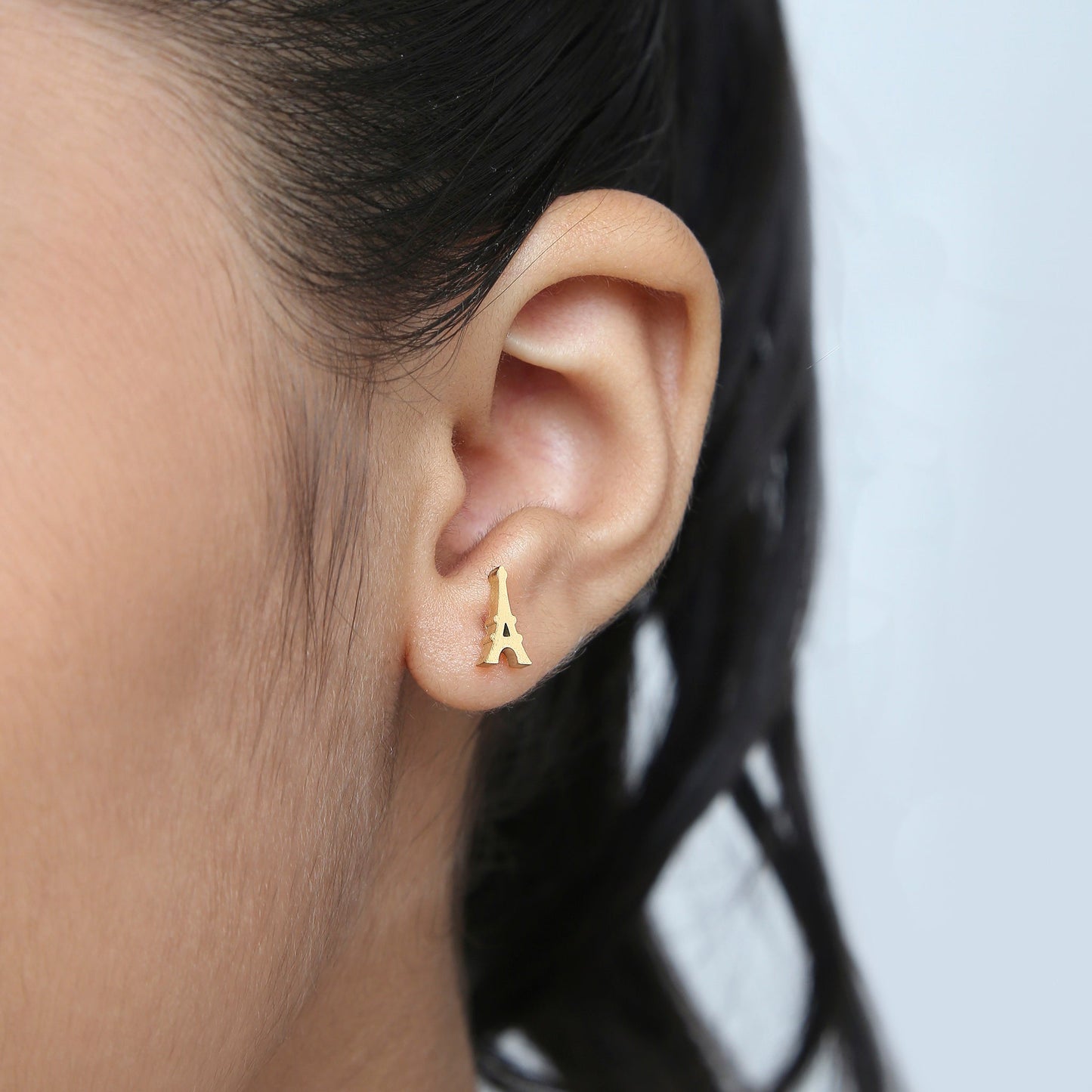 Girl wearing Eiffel Tower gold earrings – kids jewellery by Twisty Locks